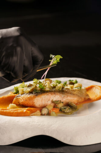 Grilled salmon fillet with Scandinavian sauce, served on seasonal vegetable purée and topped with fresh microgreens, from Pullman Tbilisi's menu.გრილზე მომზადებული ორაგულის ფილე სკანდინავიური სოუსით, ბოსტნეულის პიურე და ახალი მიკრომწვანილები, ფრანგული რესტორანი დიუმას მთავარი მენიუდან.