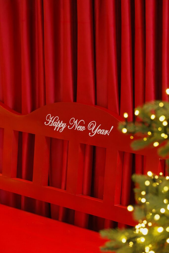 Red Happy New Year bench next to a lit Christmas tree at Pullman Tbilisi